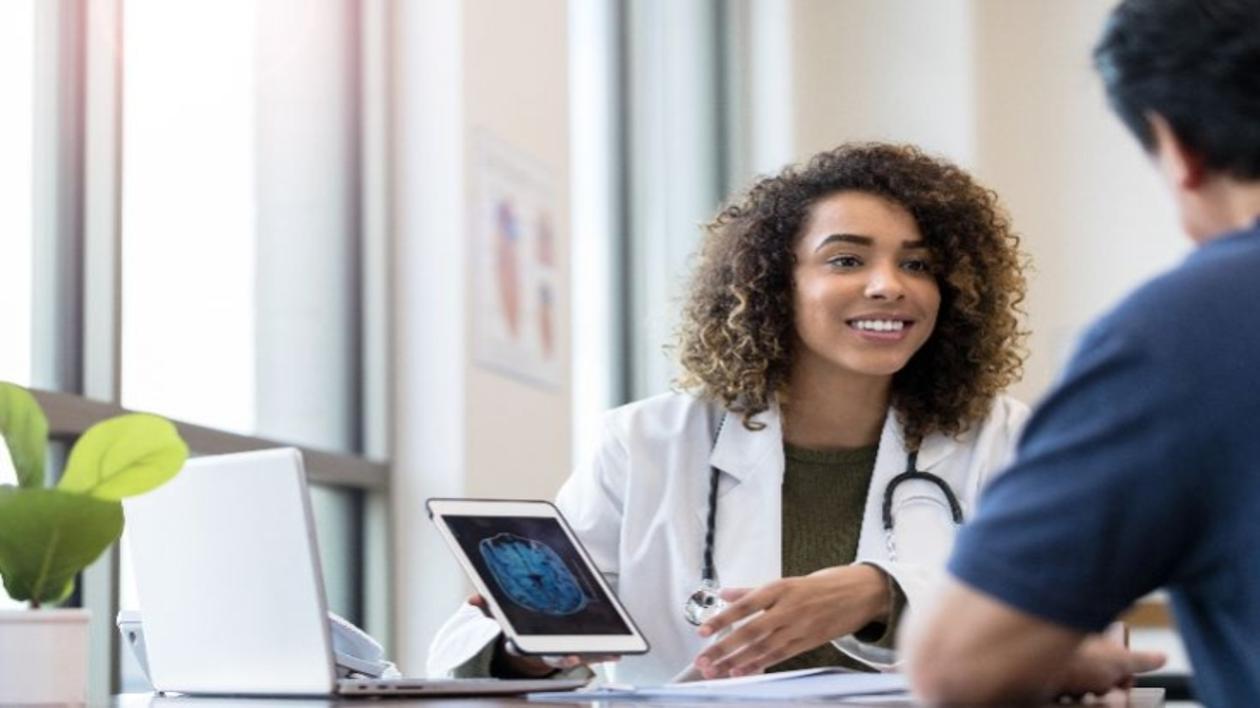 Doctor talking with a patient using a tablet.