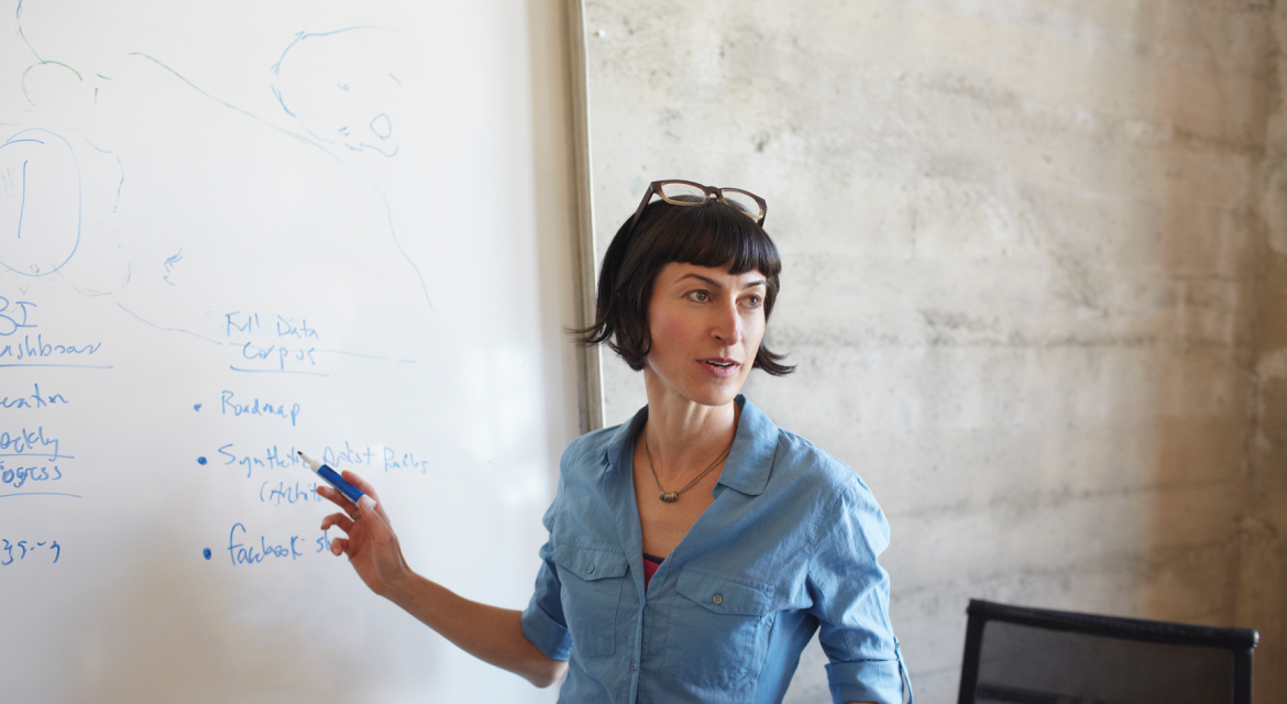 a person writing on a whiteboard