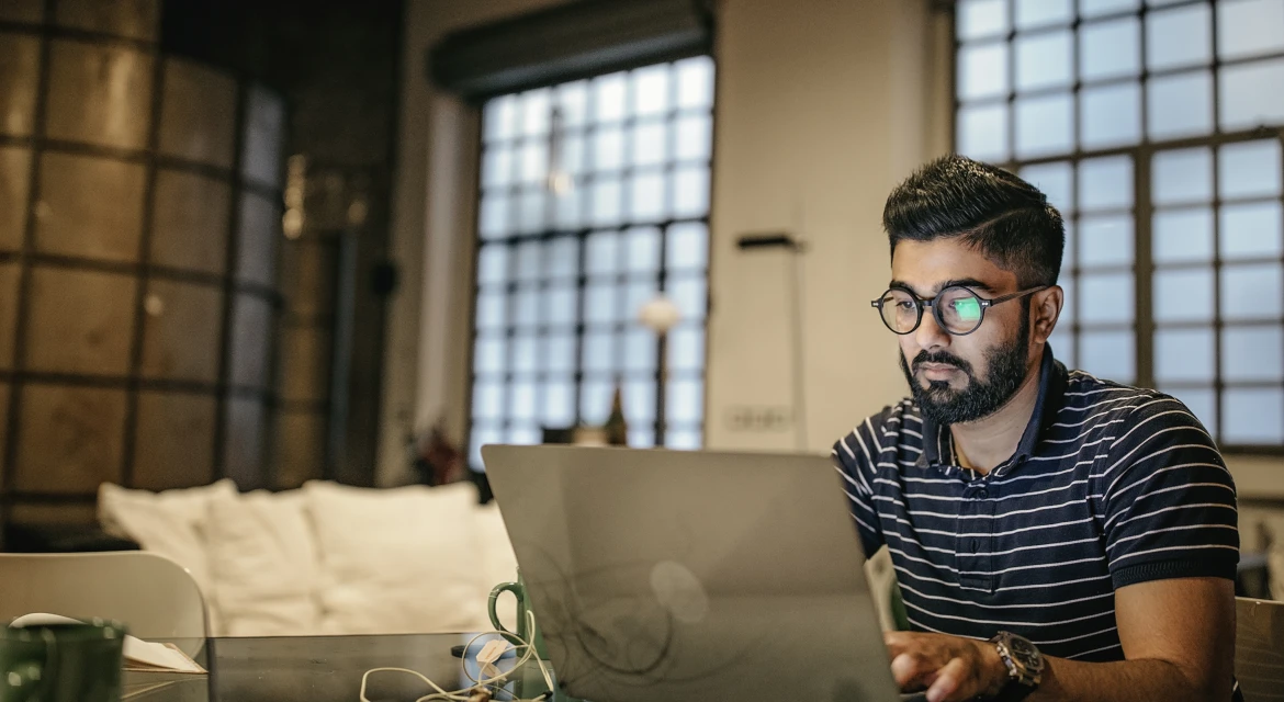 Person sitting at a table using a laptop