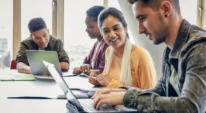 a group of people looking at a laptop