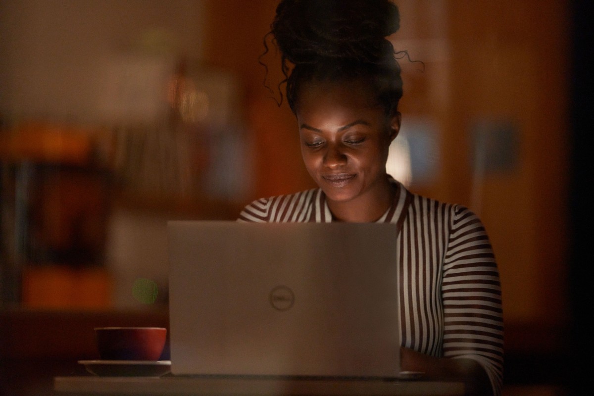 Windows photography of a young adult female inside working on a laptop