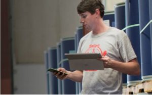 photo d'un homme avec un téléphone dans une main et un appareil de surface dans l'autre