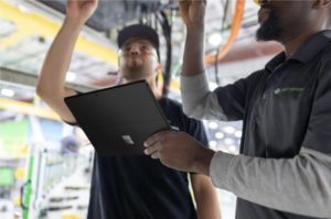 photo de deux hommes travaillant avec l'un d'eux tenant un Surface Pro