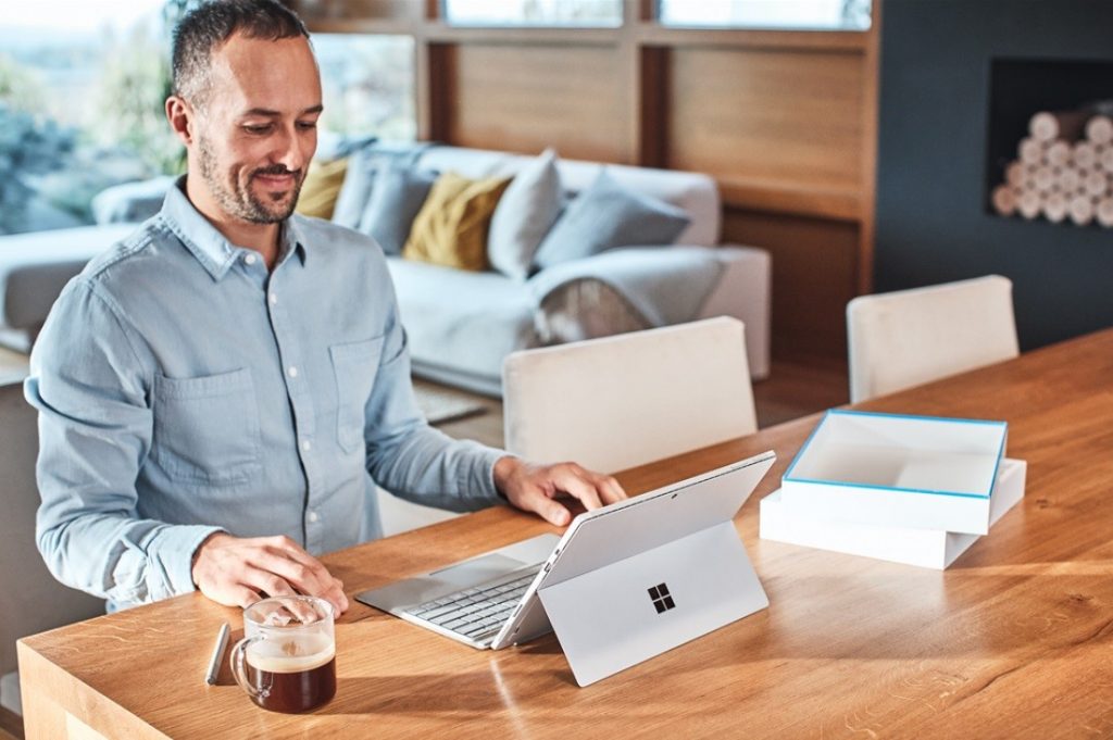 Photo d’un professionnel assis à une table qui travaille sur un Surface Laptop.