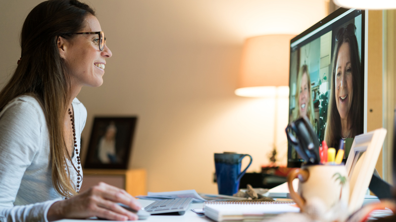 Une femme utilisant la vidéoconférence Skype pour assister à une réunion de travail