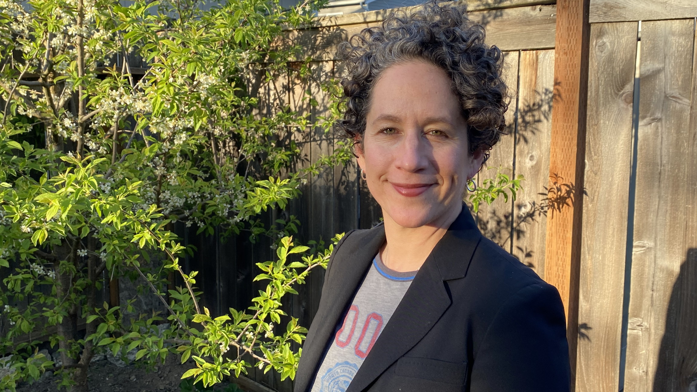 Emily Fishkind smiles in a headshot photo taken outside.