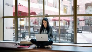A Microsoft employee uses her PC to search while sitting in an open office area in front of a window.