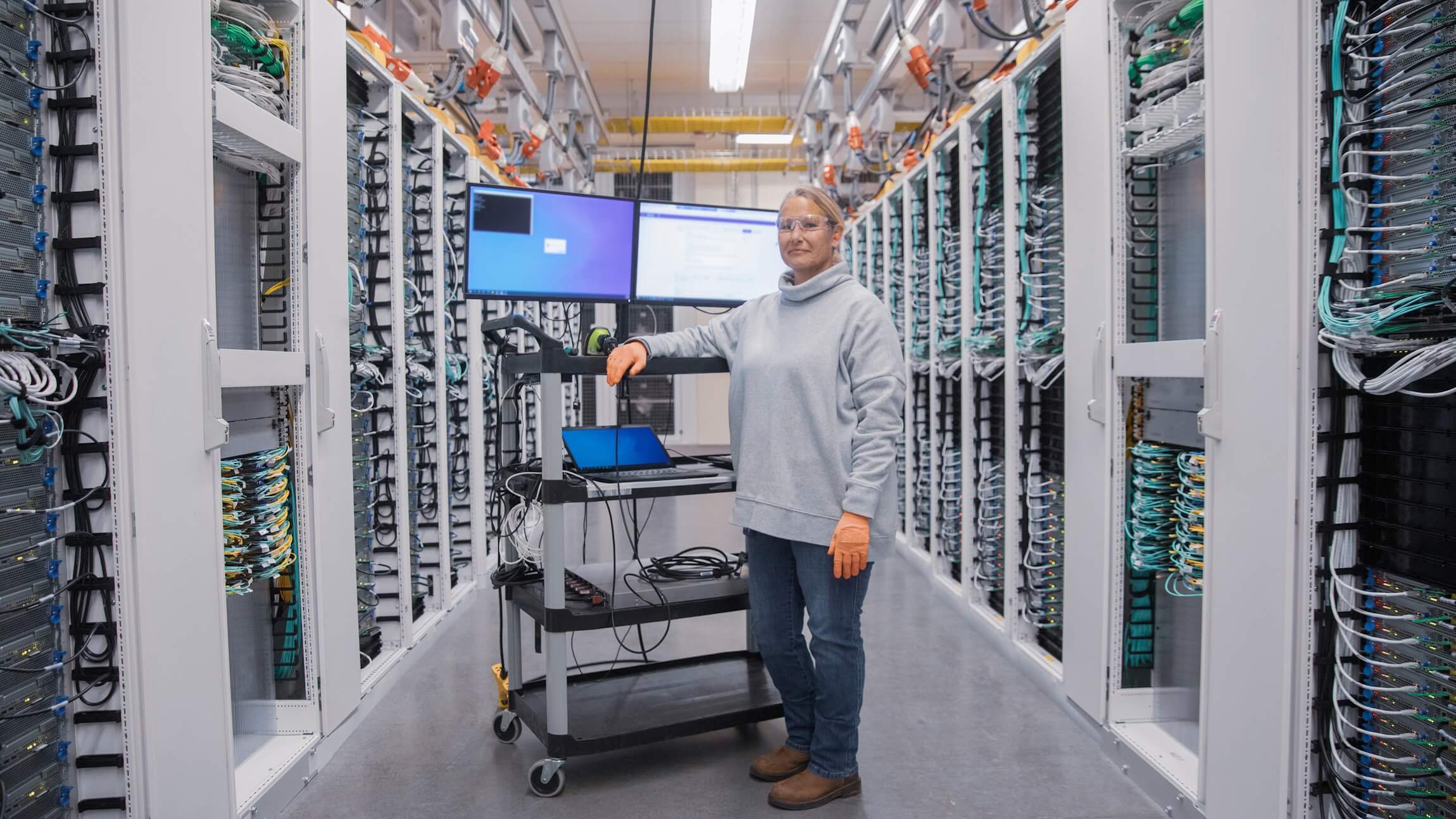 An employee in a Microsoft datacenter looks up from her mobile workstation.