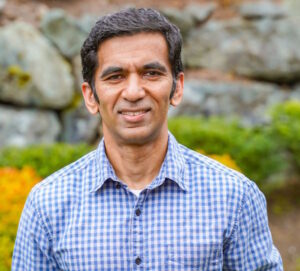 Ravindran smiles in a corporate portrait photo.