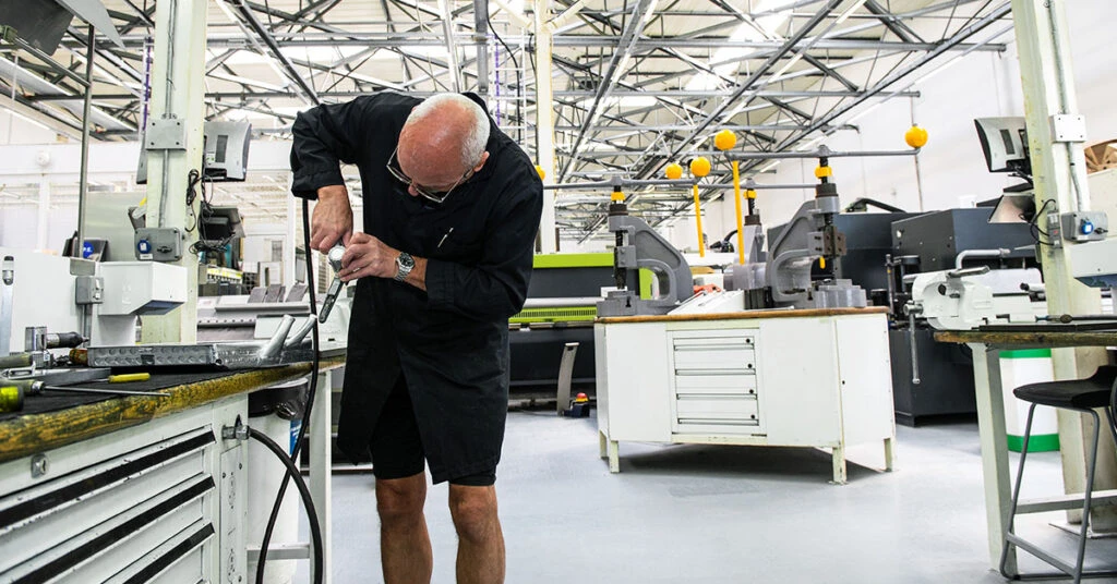 F1 の製造工場でレーシング カーのパーツが手作業で組み立てられている様子