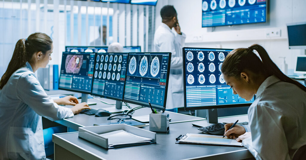 モニターで患者情報を見ながら作業する医師達