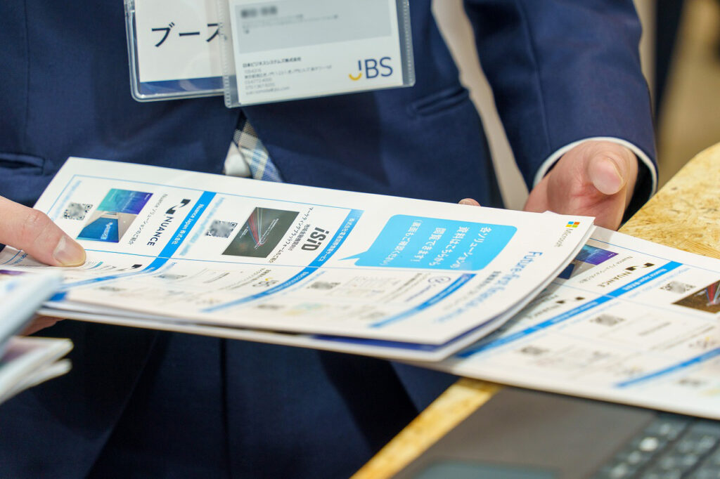 ソリューションカタログの配布準備をする様子の手元写真