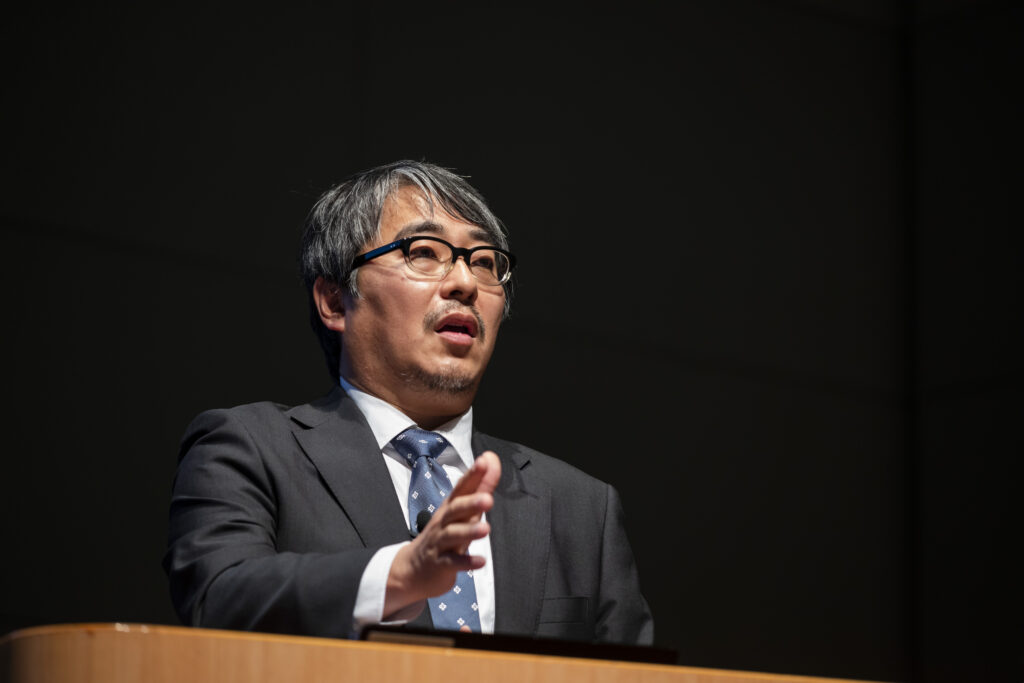 壇上にて講演する男性