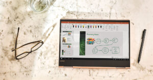テーブルの上に並ぶ眼鏡と Surface デバイス
