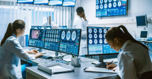 女性たちがモニターを確認しながら紙に記入している様子