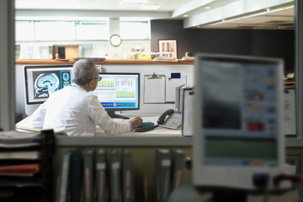 A man sitting at a desk looking at a computer