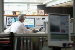 A man sitting at a desk looking at a computer