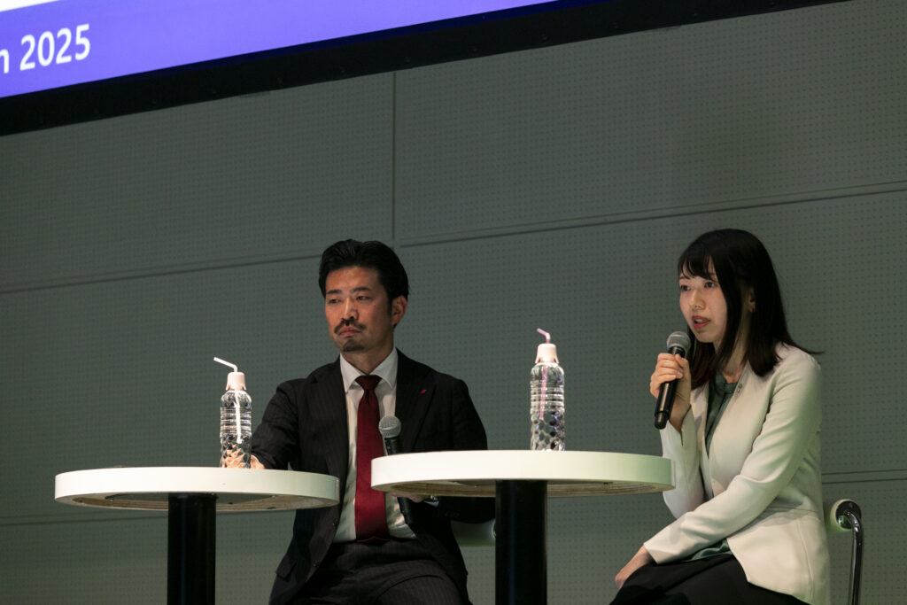 A man and woman sitting at tables with microphones