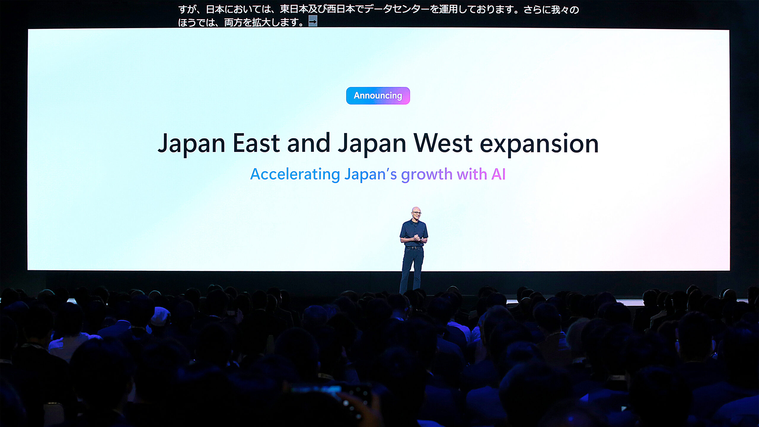 A man standing in front of a large screen