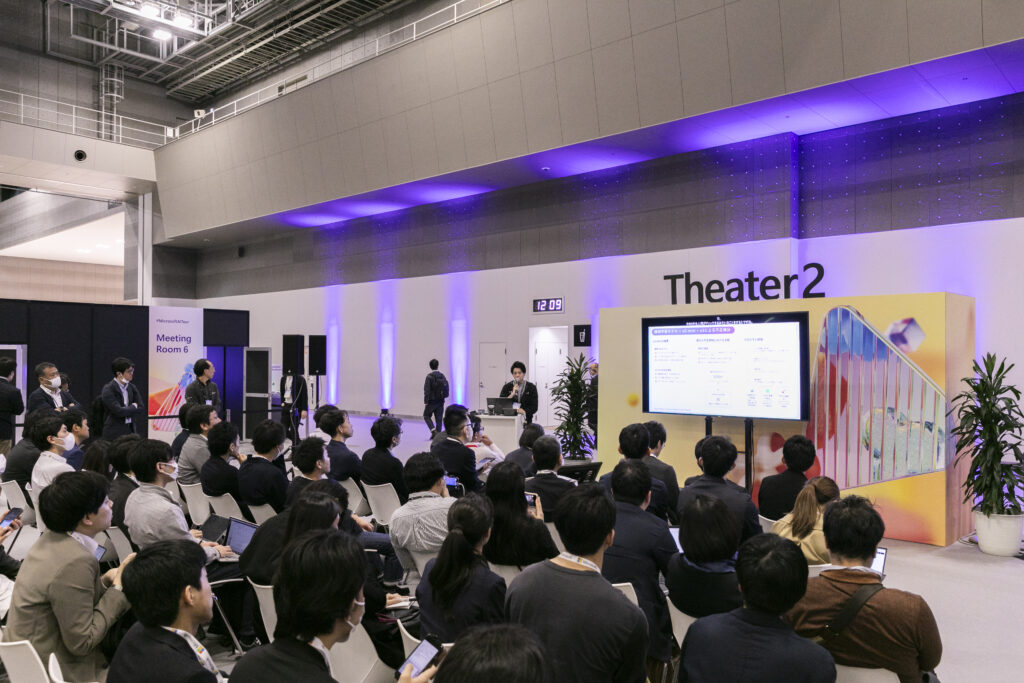 A group of people sitting in chairs in front of a stage
