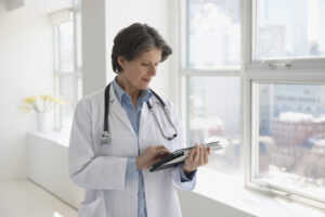 Female doctor looking at her clinical notes on a tablet.