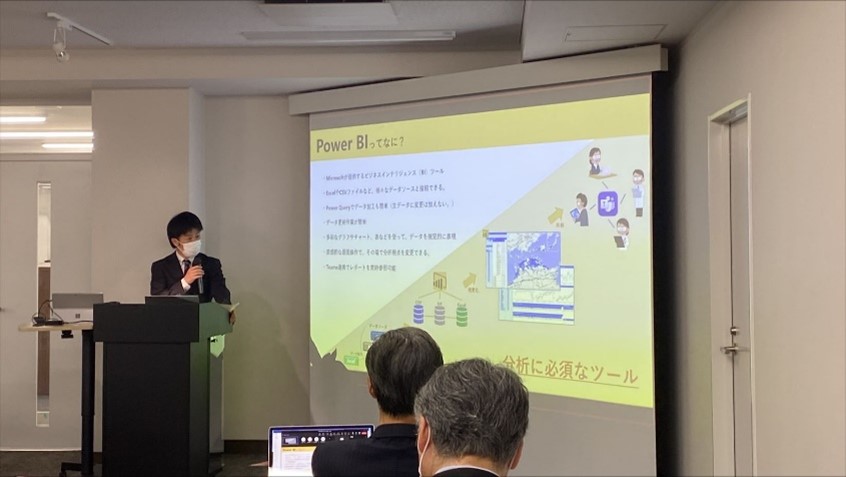 セミナールームで資料を投影しながらプレゼンを行う様子/「Power BI ってなに?」のスライド