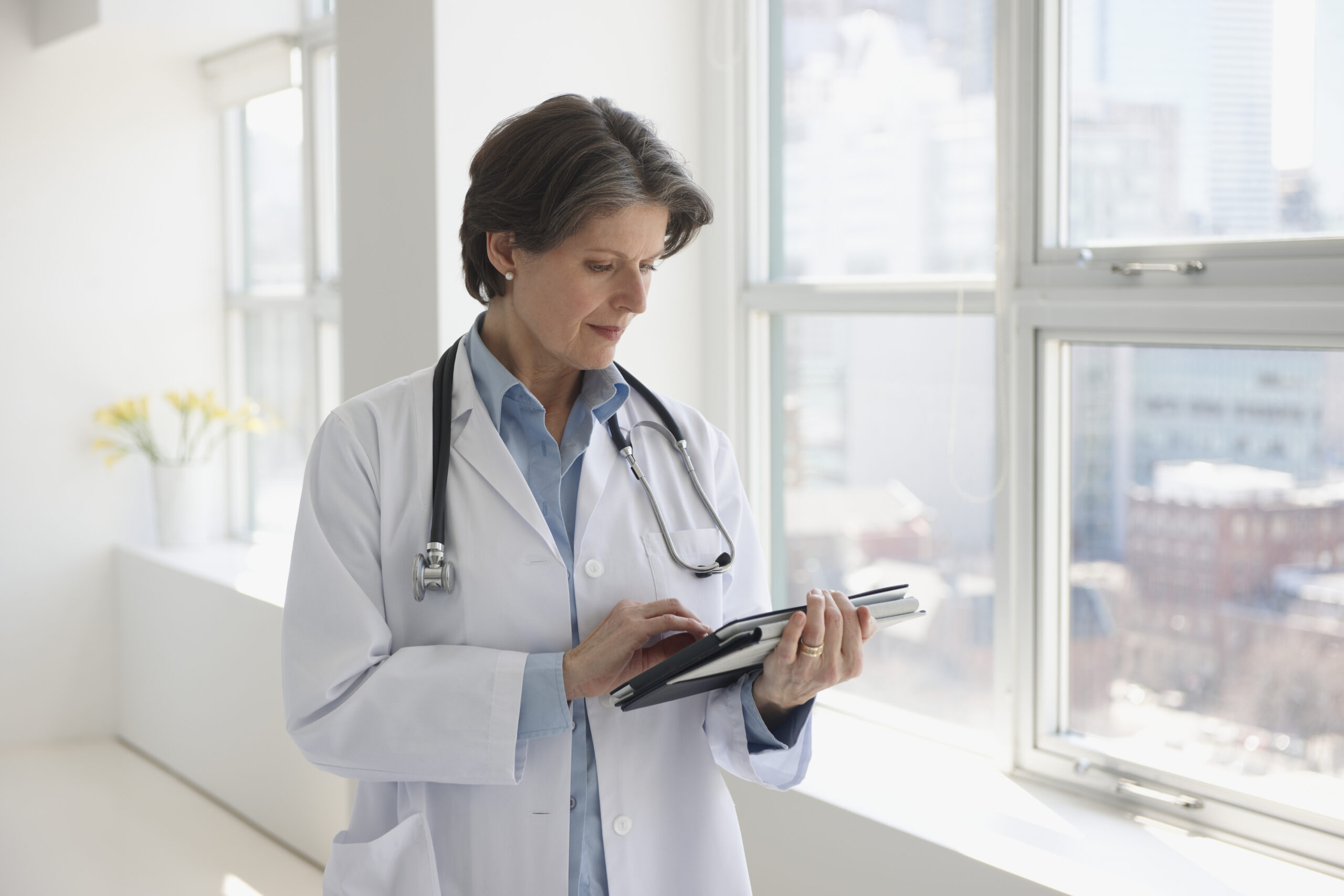 Female doctor looking at her clinical notes on a tablet