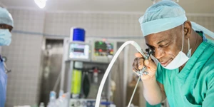 Homem em ambiente médico olhando para um aparelho