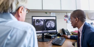 Duas pessoas olhando uma imagem médica no computador