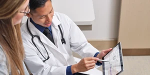 Médico mostrando dados através do tablet