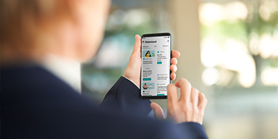 Pessoa olhando para o celular com tela de app aberta