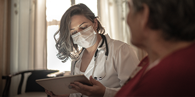 M&eacute;dica olhando para dispositivo