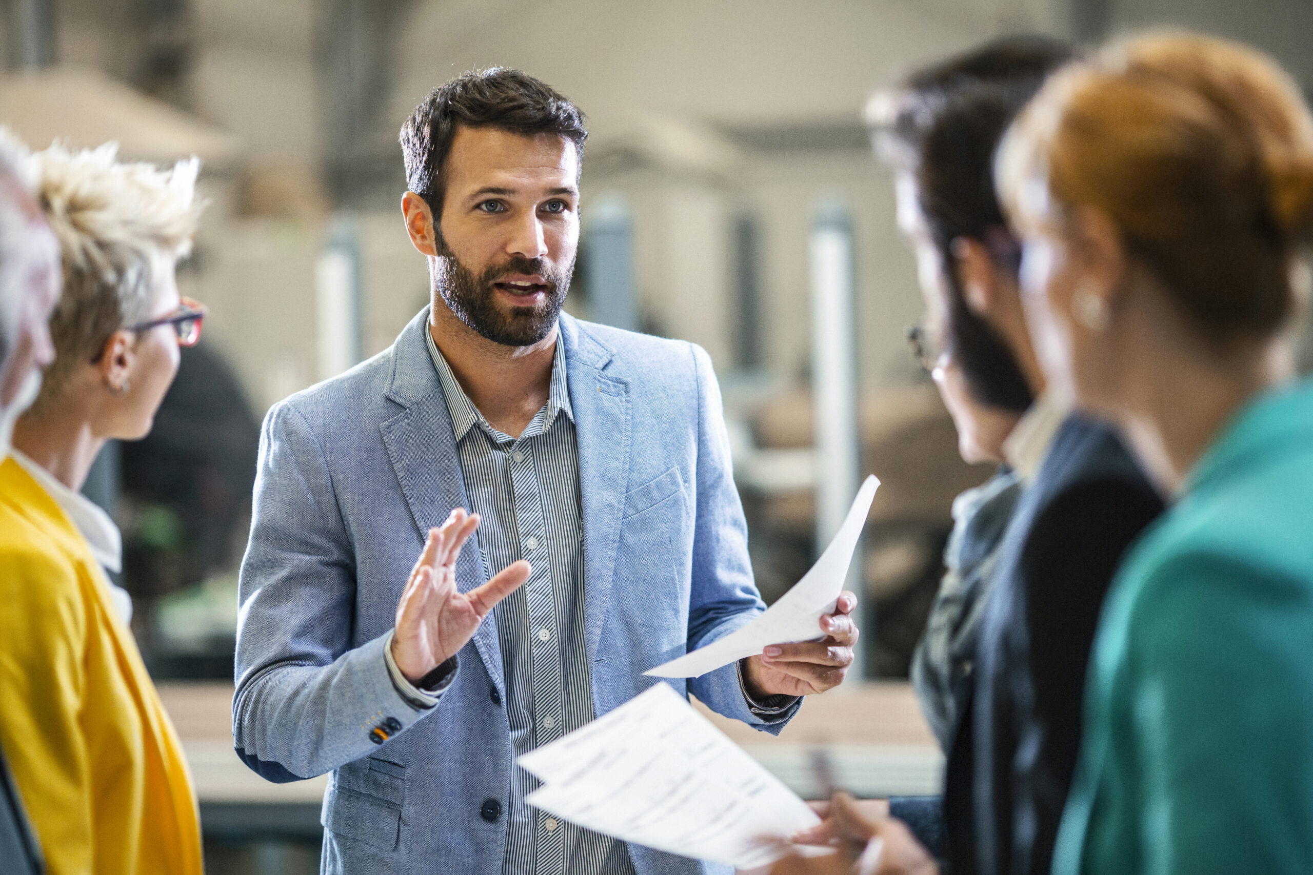 O propriet&aacute;rio de uma empresa analisa planos e estrat&eacute;gias com seus funcion&aacute;rios